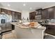 Kitchen with granite countertops, stainless steel appliances, and dark wood cabinets at 259 Blue Cypress Dr, Groveland, FL 34736