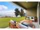 Relaxing covered patio with comfortable seating, offering serene views of the lush lawn and waterfront at 259 Blue Cypress Dr, Groveland, FL 34736