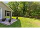 Spacious backyard with lush green grass and mature trees, with a view of the house and patio at 2607 Stanmore Ct, Orlando, FL 32817