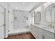 Bathroom boasts a frameless glass shower, marble tile, and dual sinks at 2607 Stanmore Ct, Orlando, FL 32817