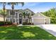 Inviting two-story home with a three-car garage, lush lawn, and elegant landscaping at 2607 Stanmore Ct, Orlando, FL 32817