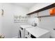 This laundry room features a front load washer and dryer with wood shelving, and modern decorative features at 2607 Stanmore Ct, Orlando, FL 32817
