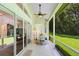 Screened porch with a ceiling fan and an outdoor seating area, with views of the expansive green yard at 2607 Stanmore Ct, Orlando, FL 32817