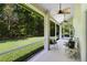 Screened porch with outdoor seating and ceiling fans, overlooking a spacious yard with green grass and trees at 2607 Stanmore Ct, Orlando, FL 32817