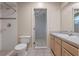 Bright bathroom featuring a tile shower, toilet, and a sink with a light wood vanity at 2633 Pickett Downs Dr, Chuluota, FL 32766