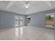 Spacious primary bedroom with tile floors, a ceiling fan, and double doors to the yard at 2633 Pickett Downs Dr, Chuluota, FL 32766