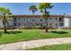 Well-manicured condominium building with lush greenery and palm trees creating curb appeal at 2818 Plaza Terrace Dr # 2818, Orlando, FL 32803