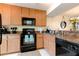 Functional kitchen featuring wooden cabinetry and essential appliances for cooking convenience at 2818 Plaza Terrace Dr # 2818, Orlando, FL 32803