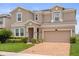 Beautiful two-story home featuring a brick paver driveway, two-car garage, and stone accents at 2940 Nottel Dr, St Cloud, FL 34772
