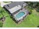Aerial shot of a property showcasing a screened pool and well-maintained lawn at 303 S Sweetwater Blvd, Longwood, FL 32779