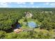 Aerial view of tennis courts, a lake, a dock and the surrounding green space in the community at 303 S Sweetwater Blvd, Longwood, FL 32779