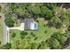 Aerial view of the property with a private pool, manicured lawn, and lush landscaping at 303 S Sweetwater Blvd, Longwood, FL 32779