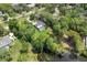 An aerial view shows a home with a pool surrounded by mature trees and lush landscaping at 303 S Sweetwater Blvd, Longwood, FL 32779