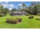 A sprawling lawn and mature trees surround a home with a screened-in pool and patio at 303 S Sweetwater Blvd, Longwood, FL 32779