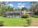 A lovely screened-in pool and patio are surrounded by a lush lawn and mature trees at 303 S Sweetwater Blvd, Longwood, FL 32779
