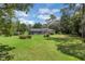 A sprawling lawn and mature trees surround a home with a screened-in pool and patio at 303 S Sweetwater Blvd, Longwood, FL 32779