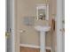 Traditional bathroom with pedestal sink, decorative wallpaper, and gold fixtures at 303 S Sweetwater Blvd, Longwood, FL 32779