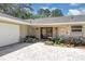 Charming home exterior with brick driveway, stone accents, and lush landscaping at 303 S Sweetwater Blvd, Longwood, FL 32779