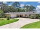 Charming ranch-style home with brick circular drive, lush lawn, mature trees and stone accents at 303 S Sweetwater Blvd, Longwood, FL 32779