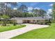 Charming ranch-style home with brick circular drive, lush lawn, mature trees and stone accents at 303 S Sweetwater Blvd, Longwood, FL 32779