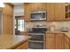 Kitchen area with stainless steel microwave and double oven, granite countertops, and wooden cabinetry at 303 S Sweetwater Blvd, Longwood, FL 32779