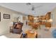 View of the kitchen area from living room, showcasing open floor plan, wooden cabinets, and breakfast nook at 303 S Sweetwater Blvd, Longwood, FL 32779