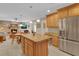 Open kitchen layout with stainless steel refrigerator, granite island, and view into the living space at 303 S Sweetwater Blvd, Longwood, FL 32779
