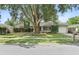 Charming single-story home featuring well-maintained landscaping, a lovely lawn, and mature shade trees at 3054 Bluebrook Dr, Winter Park, FL 32792