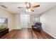 Cozy living room featuring wood floors, a ceiling fan, and a comfortable chair at 3112 Seaview Castle Dr, Kissimmee, FL 34746