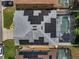 Aerial view of a home's solar panels and screened-in pool, situated amongst neighboring properties at 325 Aldridge Ln, Davenport, FL 33897