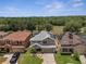 Aerial view of a two-story home with solar panels, a manicured lawn and beautiful landscaping at 325 Aldridge Ln, Davenport, FL 33897