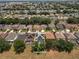 Aerial view of a neighborhood featuring homes with solar panels and pools, surrounded by lush greenery at 325 Aldridge Ln, Davenport, FL 33897