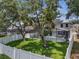 A spacious backyard features a well-maintained lawn, mature trees, and a screened-in pool enclosure for outdoor enjoyment at 325 Aldridge Ln, Davenport, FL 33897
