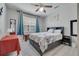 Bright bedroom featuring a ceiling fan, and a cozy bed with floral bedding and neutral-colored walls at 325 Aldridge Ln, Davenport, FL 33897