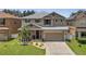 Charming two-story home with a well-manicured lawn, complemented by a two-car garage and neutral color scheme at 325 Aldridge Ln, Davenport, FL 33897