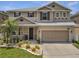 Charming two-story home with a well-manicured lawn, complemented by a two-car garage and neutral color scheme at 325 Aldridge Ln, Davenport, FL 33897