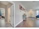 Inviting hallway with wood floors, neutral walls, and decorative wall art leading to multiple rooms at 325 Aldridge Ln, Davenport, FL 33897