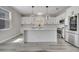 Bright kitchen with white cabinets, stainless steel appliances, pendant lighting and a large center island at 325 Aldridge Ln, Davenport, FL 33897