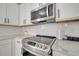 Close-up of a modern kitchen with stainless steel appliances and white cabinets at 325 Aldridge Ln, Davenport, FL 33897