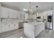 Beautiful kitchen with white cabinets, stainless steel appliances, quartz counters and stylish pendant lighting at 325 Aldridge Ln, Davenport, FL 33897