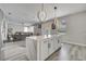 Open kitchen design with white cabinetry, an island and stainless appliances, seamlessly connecting to the living space at 325 Aldridge Ln, Davenport, FL 33897