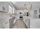 Modern kitchen featuring white cabinets, stainless steel appliances, quartz countertops and an island with seating at 325 Aldridge Ln, Davenport, FL 33897