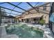 Spacious screened-in pool area with seating, dining space and view of the two-story house at 325 Aldridge Ln, Davenport, FL 33897
