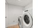 Laundry room with modern, white washer and dryer units and tiled flooring at 3591 Sandlor Dr, Deltona, FL 32738