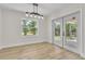 Bright dining area features a modern light fixture, wood floors, a window, and sliding glass doors to the outside at 37 N Tymber Crk, Ormond Beach, FL 32174