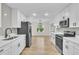 Modern kitchen featuring white cabinetry, stainless steel appliances, and light wood floors at 37 N Tymber Crk, Ormond Beach, FL 32174