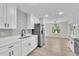 Bright kitchen boasts stainless steel appliances, white cabinetry, and light wood floors at 37 N Tymber Crk, Ormond Beach, FL 32174
