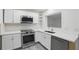 Modern kitchen featuring white cabinets, stainless steel appliances, and quartz countertops at 3927 Citadel Dr, Orlando, FL 32839