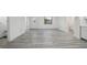 Spacious living room featuring wood-look vinyl flooring, white walls and entry door at 3927 Citadel Dr, Orlando, FL 32839
