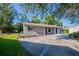 Single-story home with a concrete driveway, side yard, and stone accent walls at 4226 Kelly Miller Ct, Orlando, FL 32811